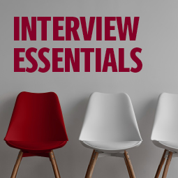 image of a row of white chairs with one garnet