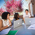Students looking at laptop and smiling