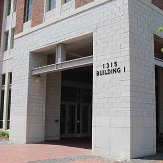 Entrance to 1315 Building I, featuring a light stone exterior, recessed doorway, and brick walkway.