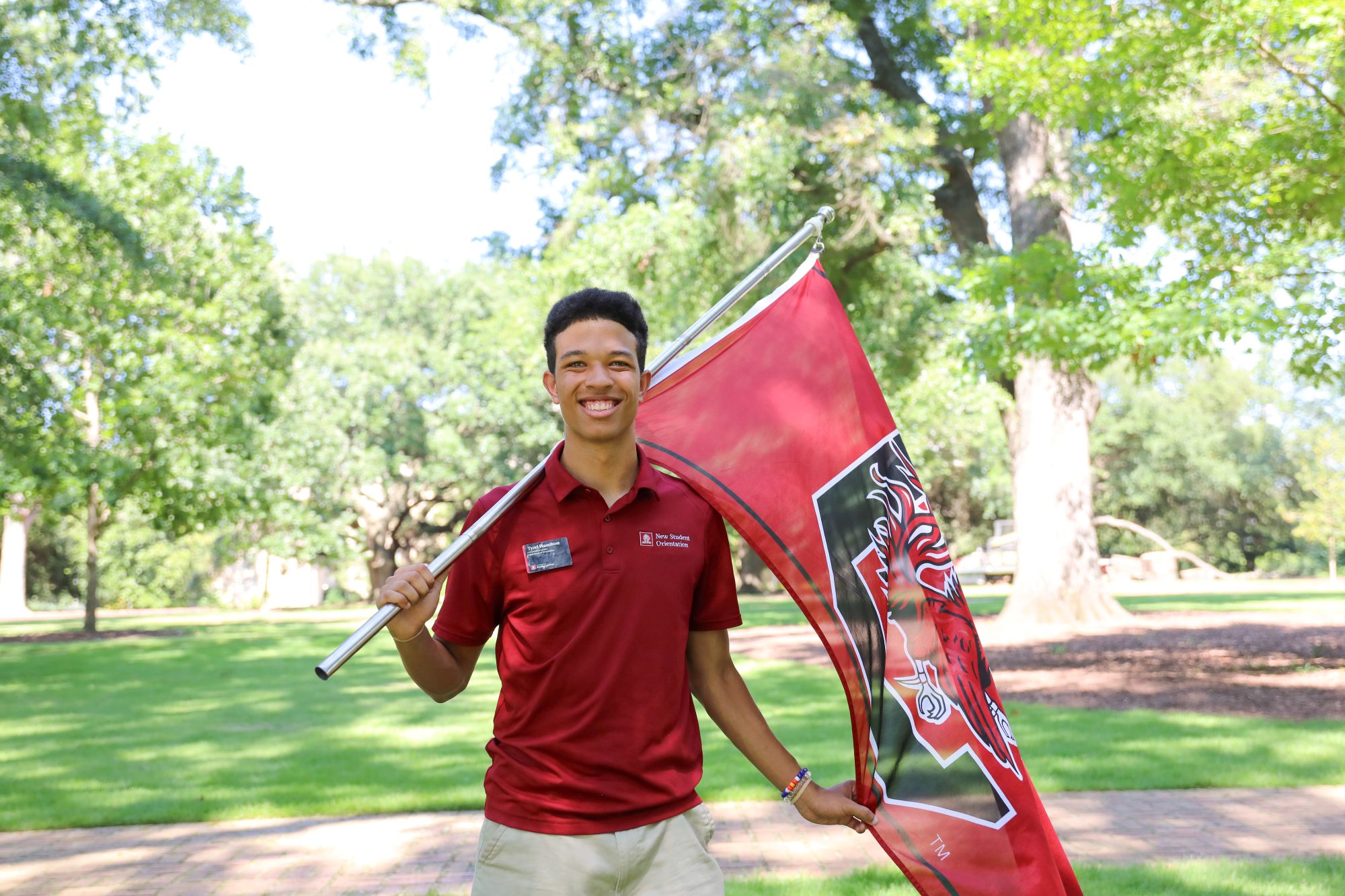 Orientation leader with a Carolina flag on the Horseshoe.