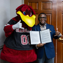 Photo of Cocky and VP J. Rex Tolliver with the Robert F. Newton Award for Distinguished Service from the National Association for College Auxiliary Services