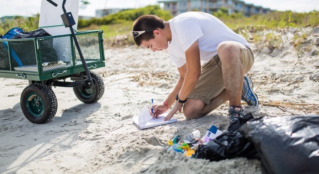 an undergrad student conducts research on the beach