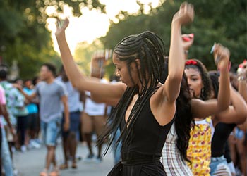 Students dancing on green street.