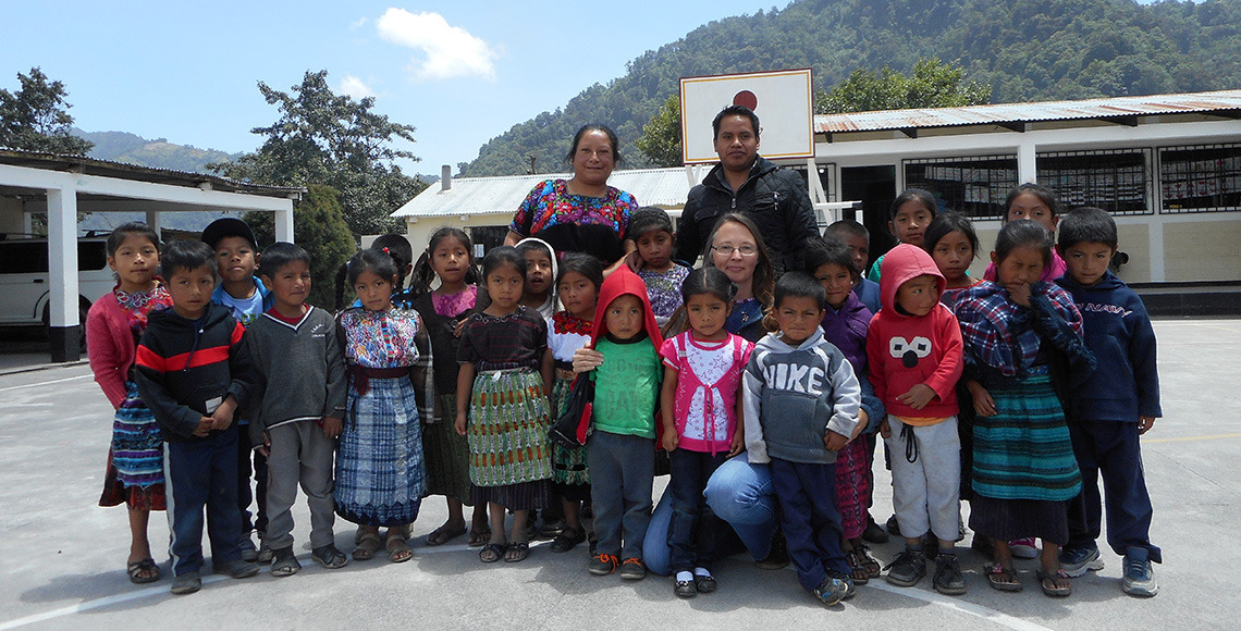 Jennifer Reynolds kneels amongst a group of Guatemalan school children during her trip to San Marin Sacatepéquez. Image by George Stoianov