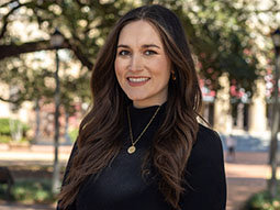 a photo of a woman wearing a black long sleeve top outside 
