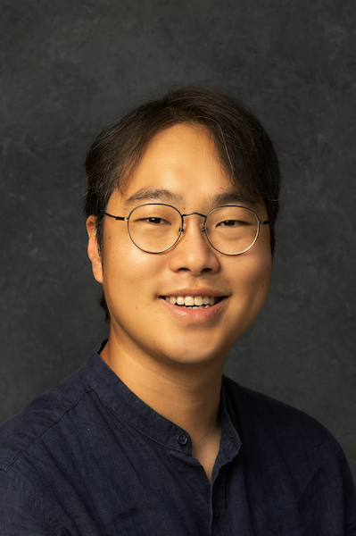 man standing outside with a light blue shirt on smiling