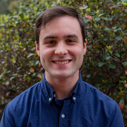 man smiling in a blue button up shirt