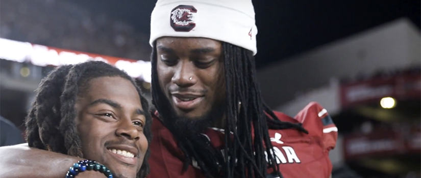 Two Gamecock football players embracing