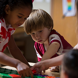 children working on a colorful puzzlze