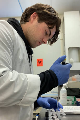 Jake Brezner using a pipette in a lab