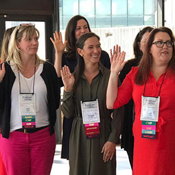 Christina Saragnese Christina Saragnese raises her right hand with a group of inductees at the Society of Government Meeting Professionals National Chapter Board meeting.