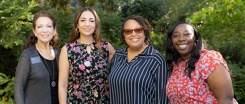Karen Edwards, Tarlan Chahardovali, Katheldra Alexander and Cierra Pinckney pose in a garden.