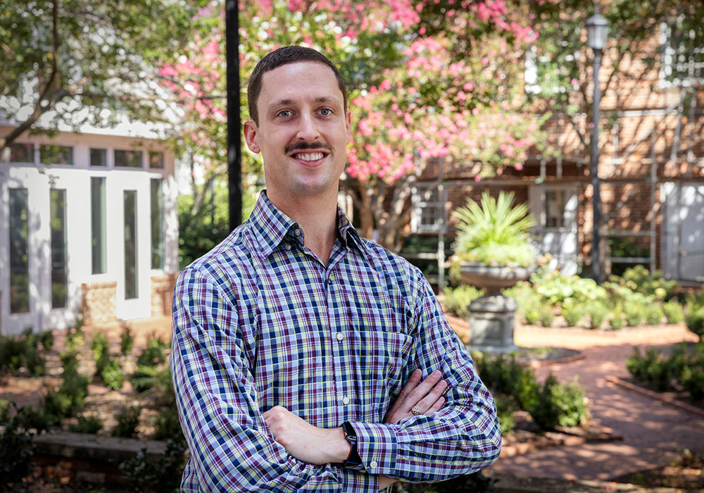 A man standing in front of a garden