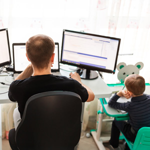 Man at home office with child beside him 
