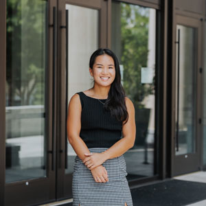 woman standing in front of the Joseph F. Rice School of Law 