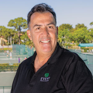 Ricardo Acioly smiles for the camera with the Evert Tennis Academy in the background.