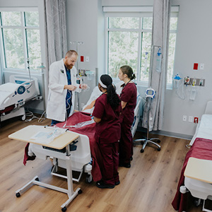 A doctor discusses a case in hospital setting with two nursing students