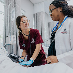 Nursing student with instructor at bedside