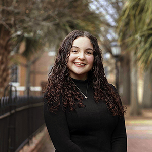 Headshot of Samantha Hinton in front of gates